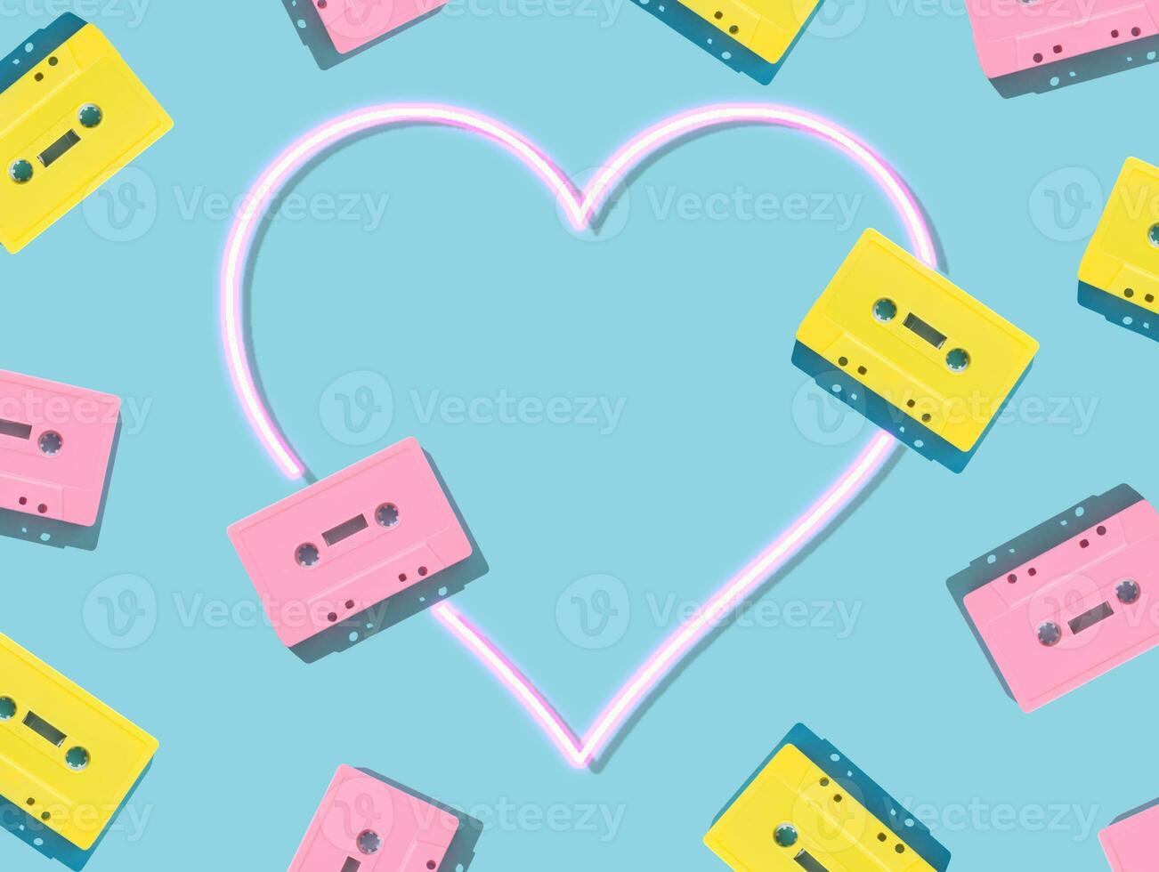 Pattern of retro pink and yellow audio cassette tapes with pink neon heart on blue background. Creative concept of retro technology. 80's aesthetic. Vintage audio cassette tape idea. Retro nostalgia. photo