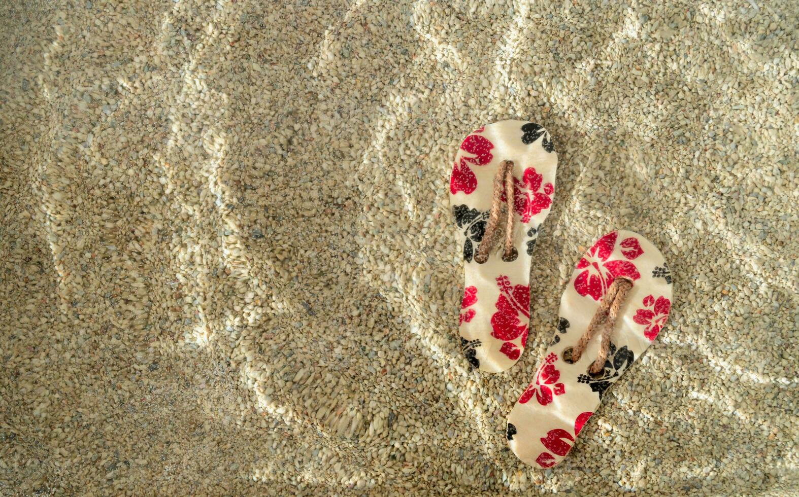 verano escena con floral zapatillas en arena en agua. Dom y oscuridad. mínimo verano concepto. de moda verano vacaciones idea. foto