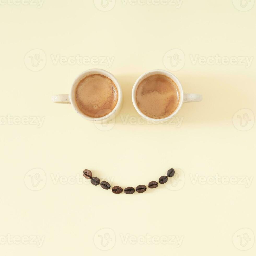 Layout of smiley emoticon made with coffee cups and coffee beans on pastel background. Minimal coffee concept. Creative positive thinking and good mood idea composition. Coffee aesthetic. Flat lay. photo