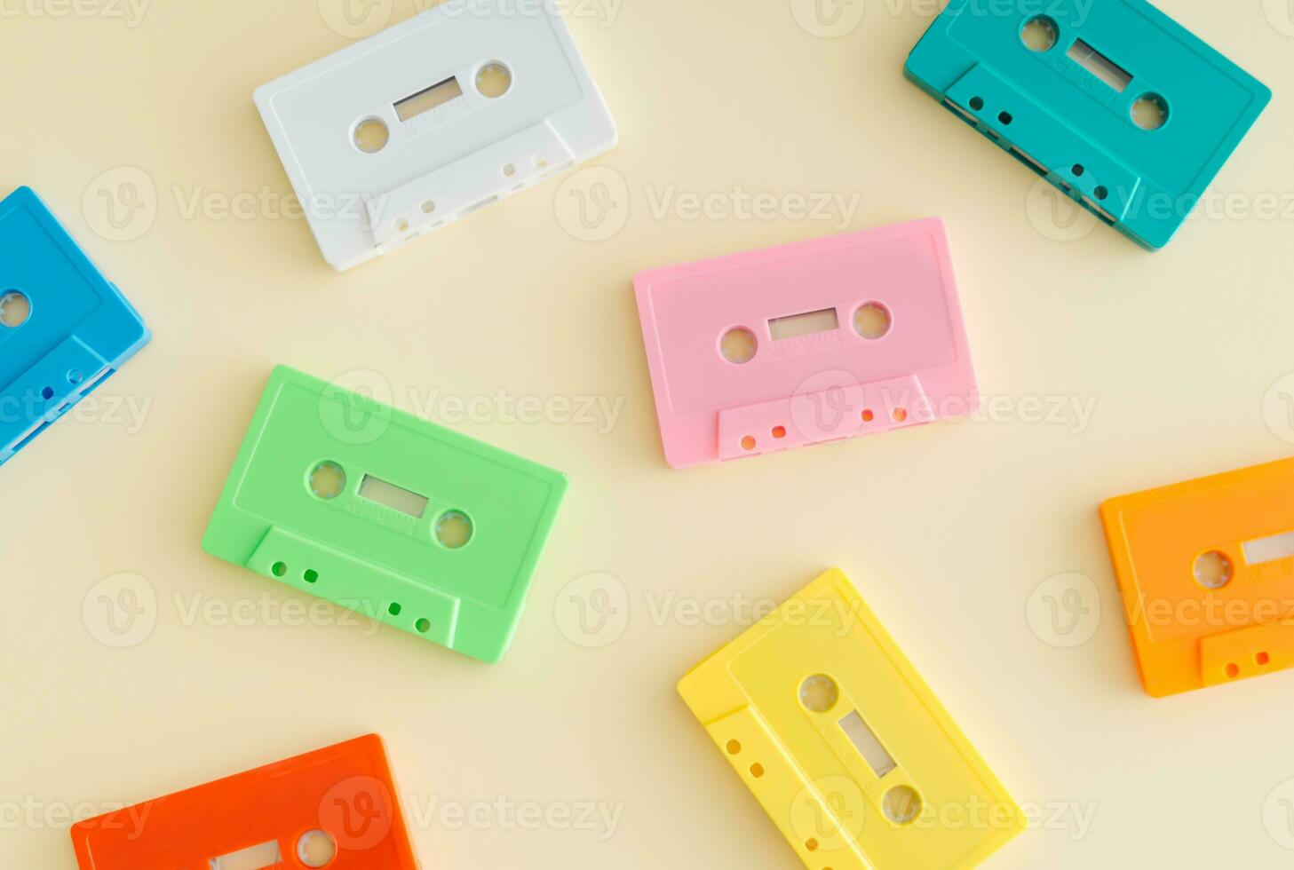 Pattern of retro colorful audio cassette tapes on pastel beige background. Creative concept of retro technology. 80's aesthetic. Vintage audio cassette tape pattern idea. Retro nostalgia. Flat lay. photo