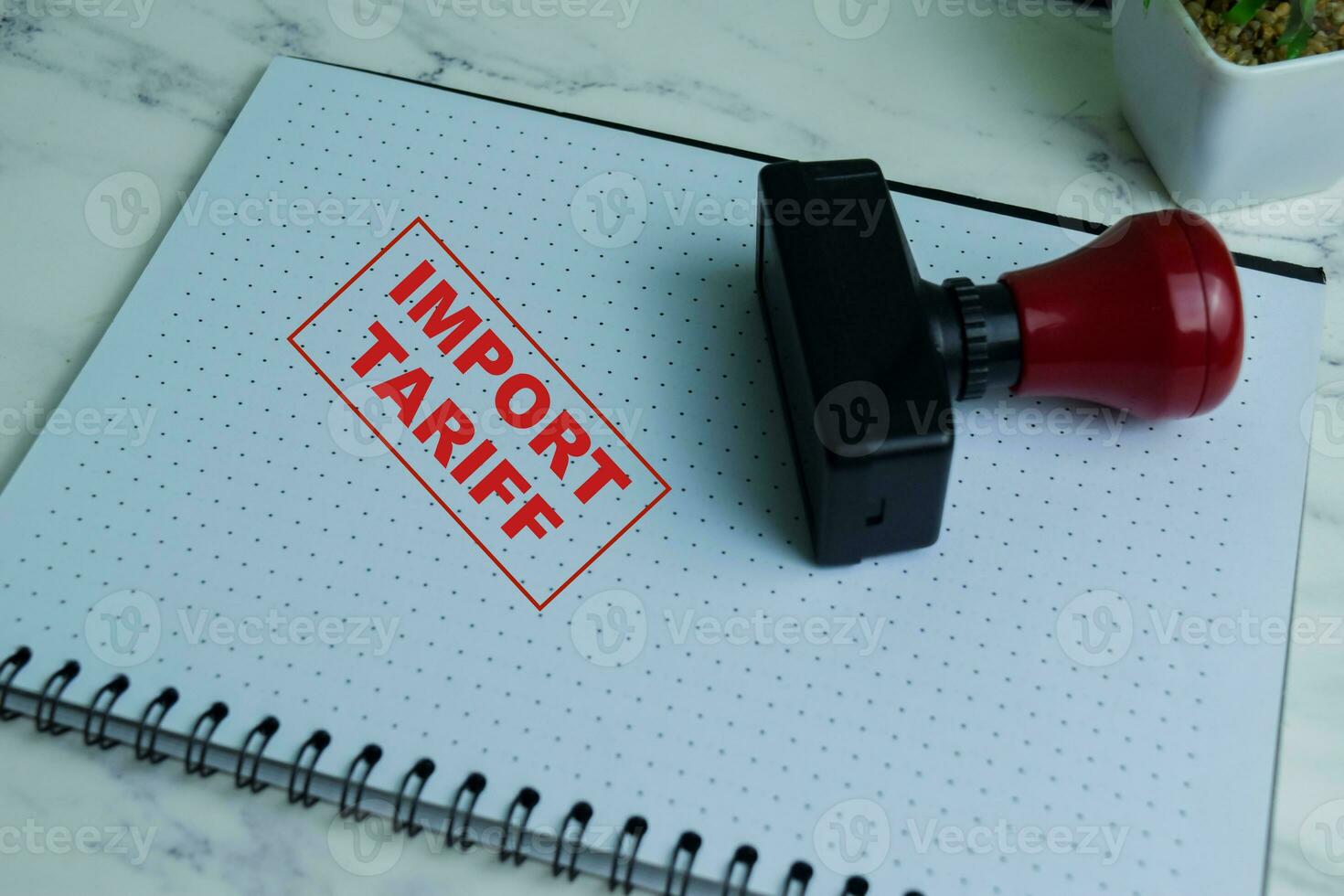Red Handle Rubber Stamper and Import Tariff text isolated on wooden background photo