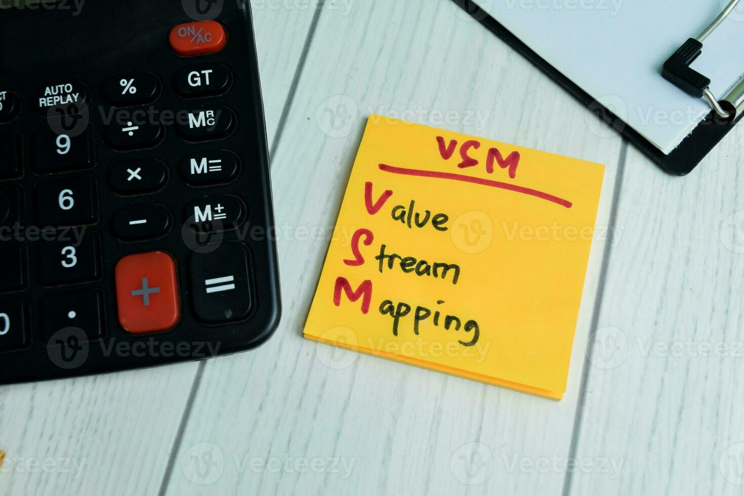 Concept of VSM - Value Stream Mapping write on sticky notes isolated on Wooden Table. photo