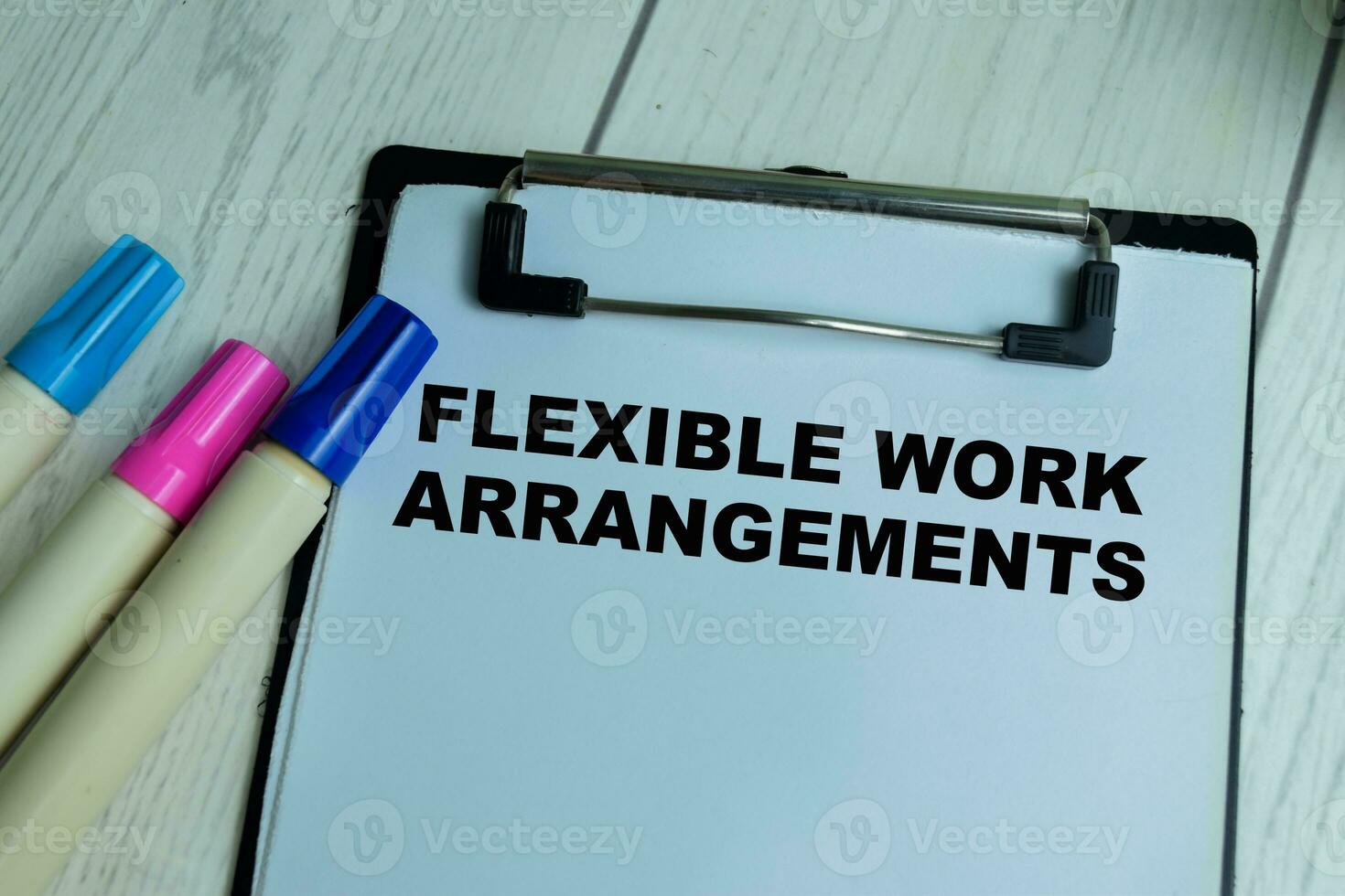 Concept of Flexible Work Arrangements write on paperwork isolated on wooden background. photo