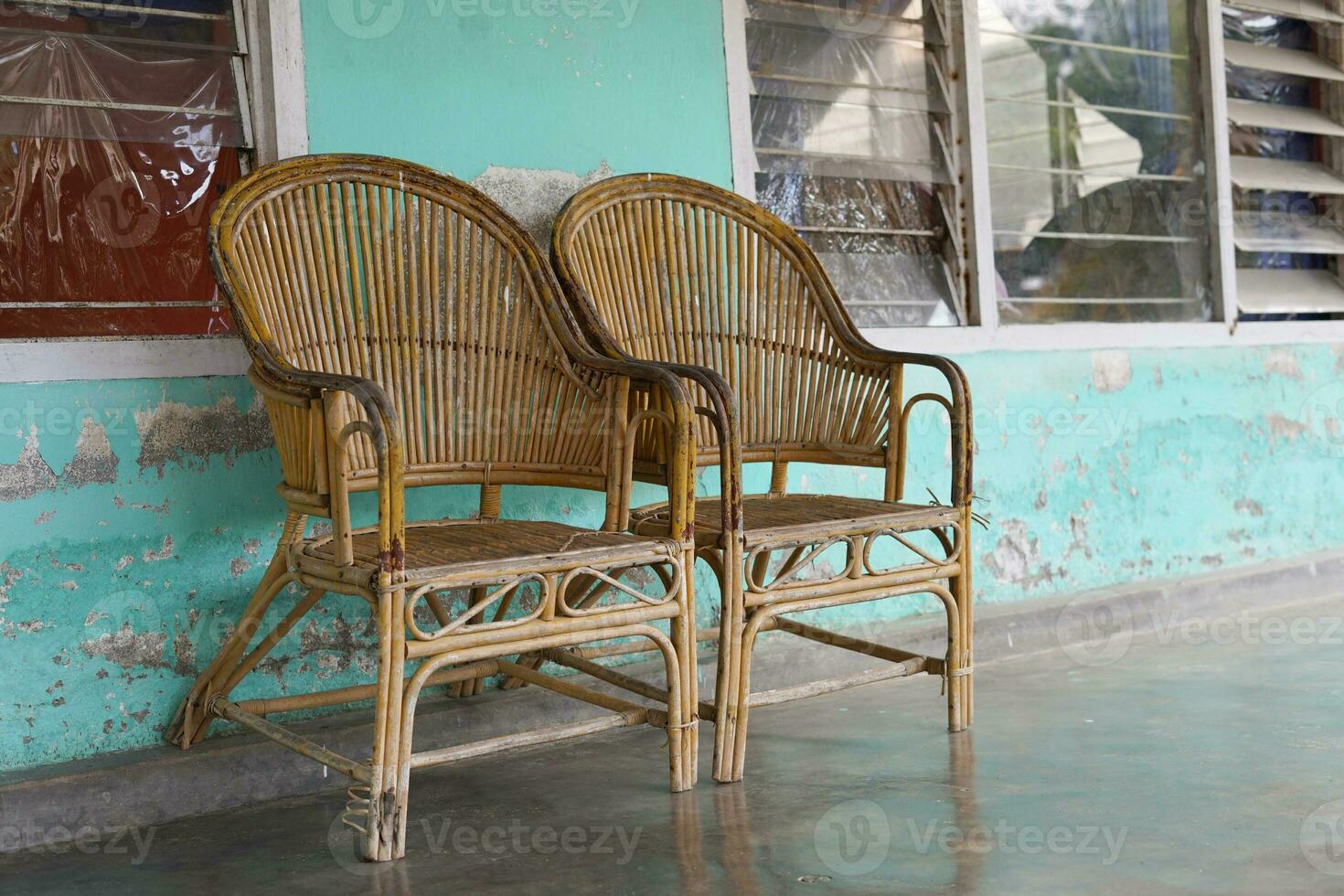 Two rattan chairs are placed on the terrace of the house photo