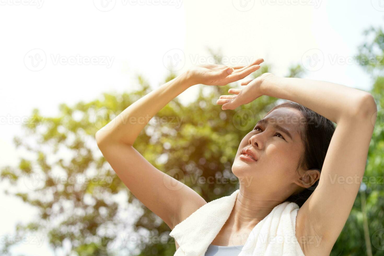 Sport asian woman gets tired and get dizzy, feel bad pain and suffer from heat stroke outdoors when jogging or exercise outdoor with strong sunlight in summer season. Heatstroke and heat wave concept. photo