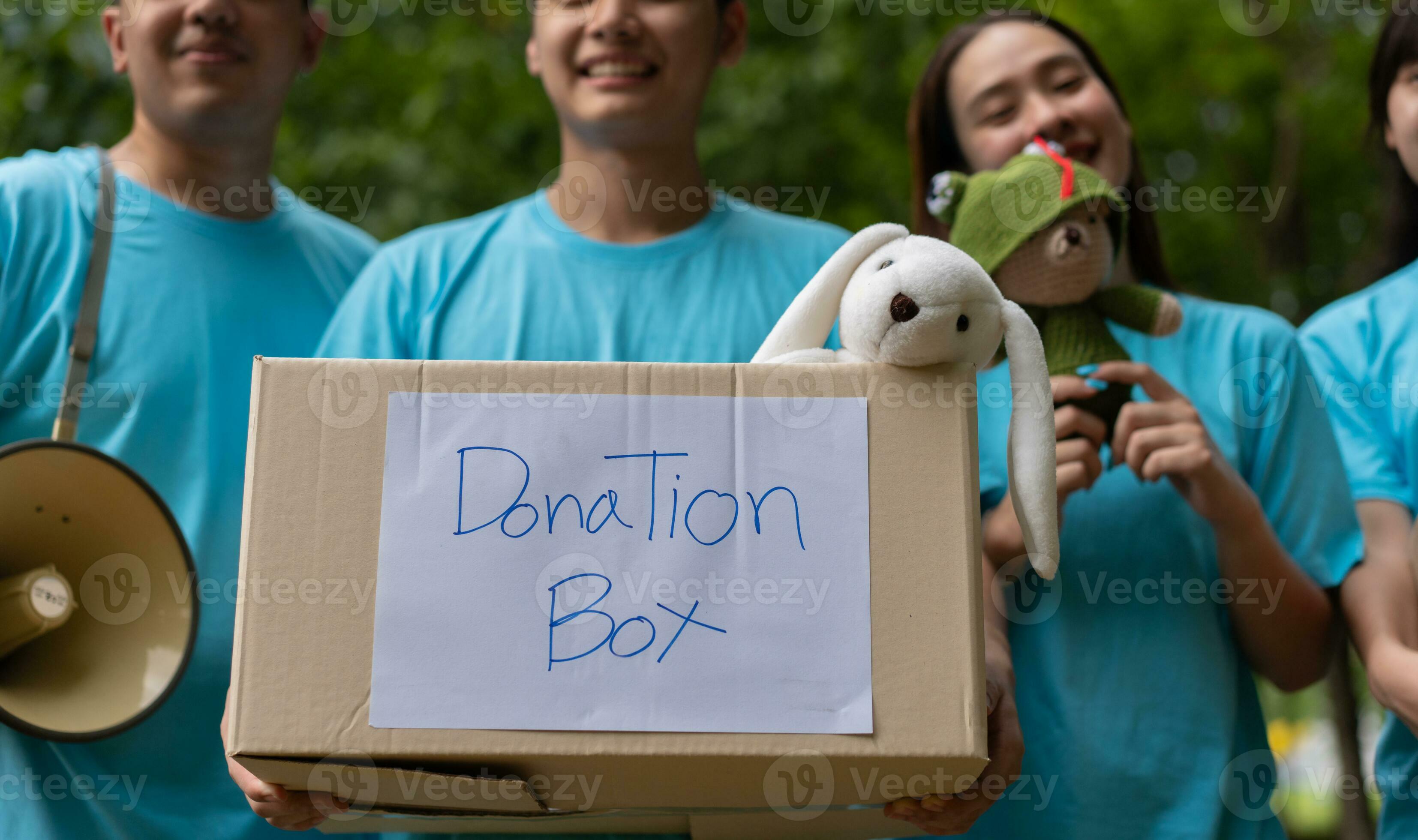 Happy young Asian students diverse volunteers hold donate box and toys