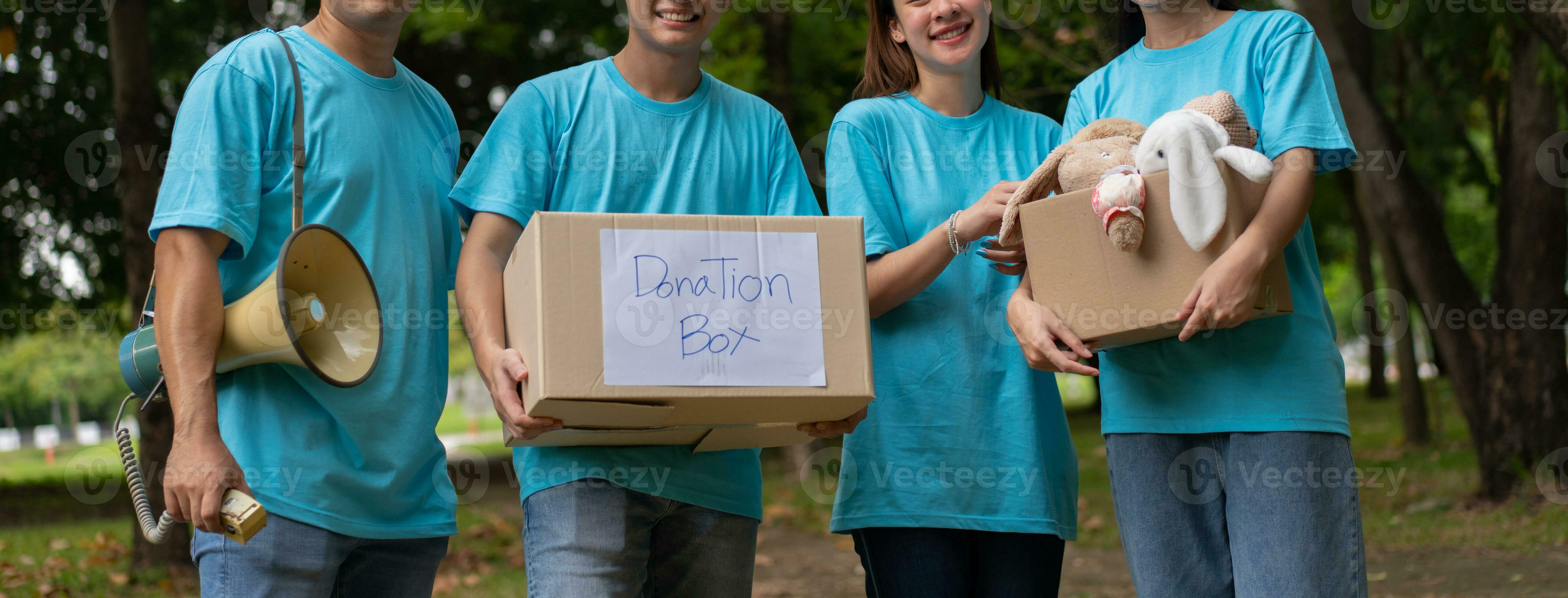 Happy young Asian students diverse volunteers hold donate box and toys