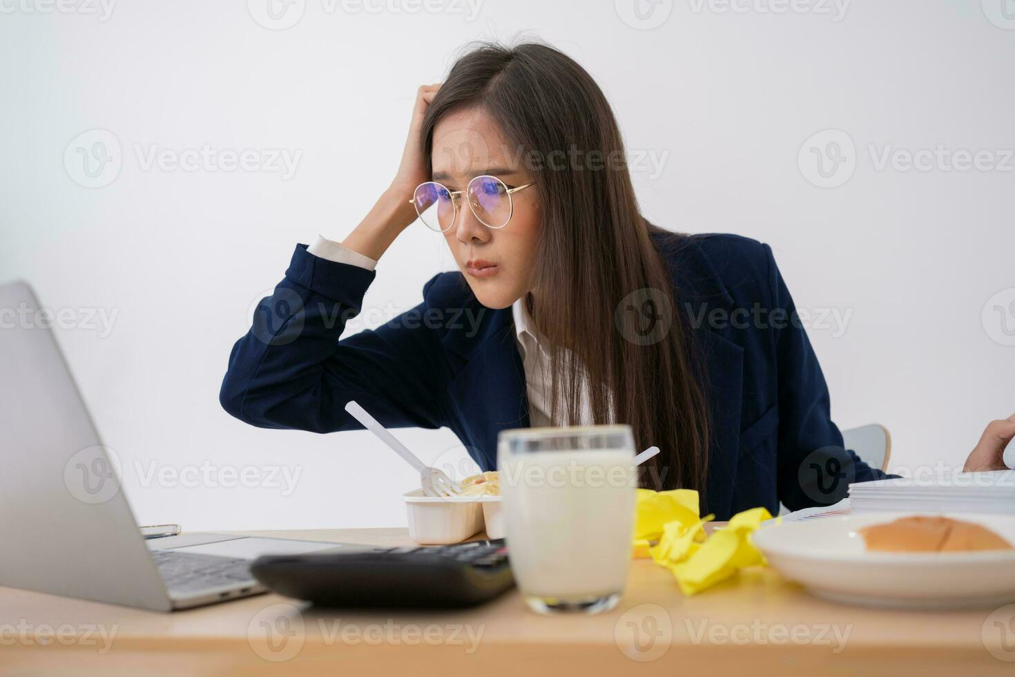 Busy and tired businesswoman eating spaghetti for lunch at the Desk office and working to deliver financial statements to a boss. Overworked and unhealthy for ready meals, burnout concept. photo