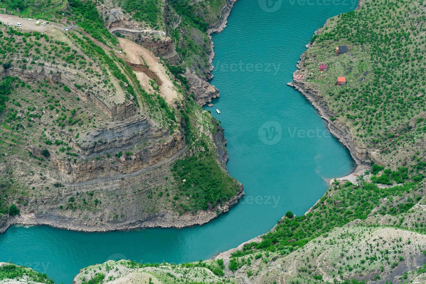 mountain landscape, a deep canyon with a blue river at the bottom, a camp site and a road under construction photo