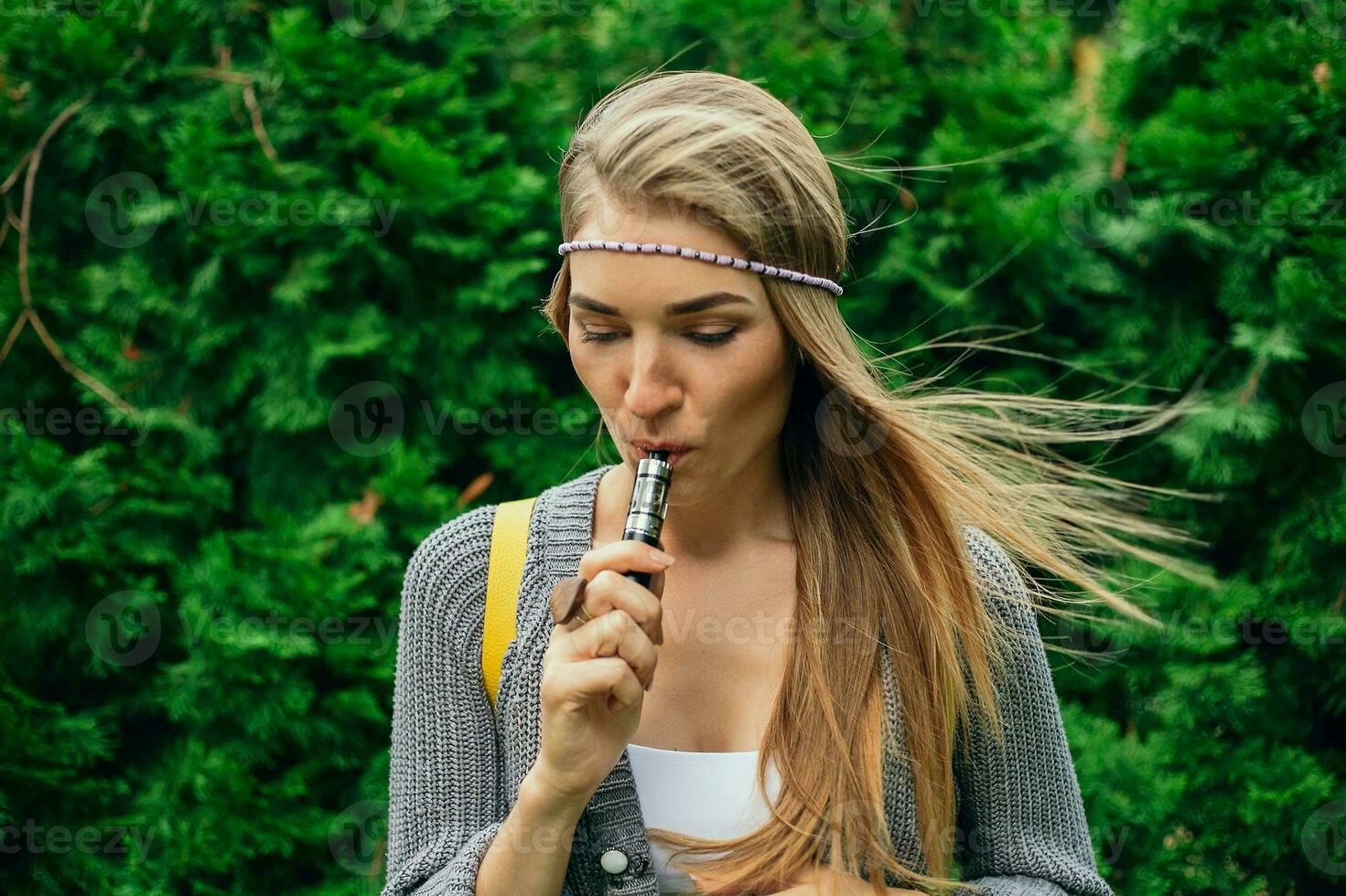 Happy vaping young white blonde girl photo