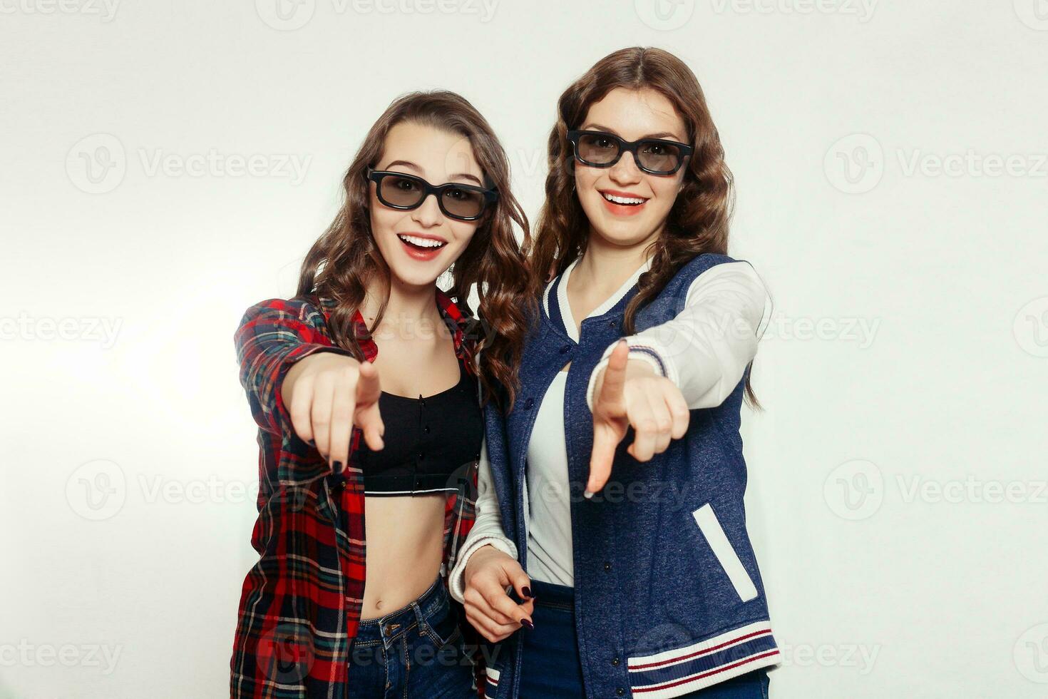 Two attractive smiling girl in a 3d-glasses photo