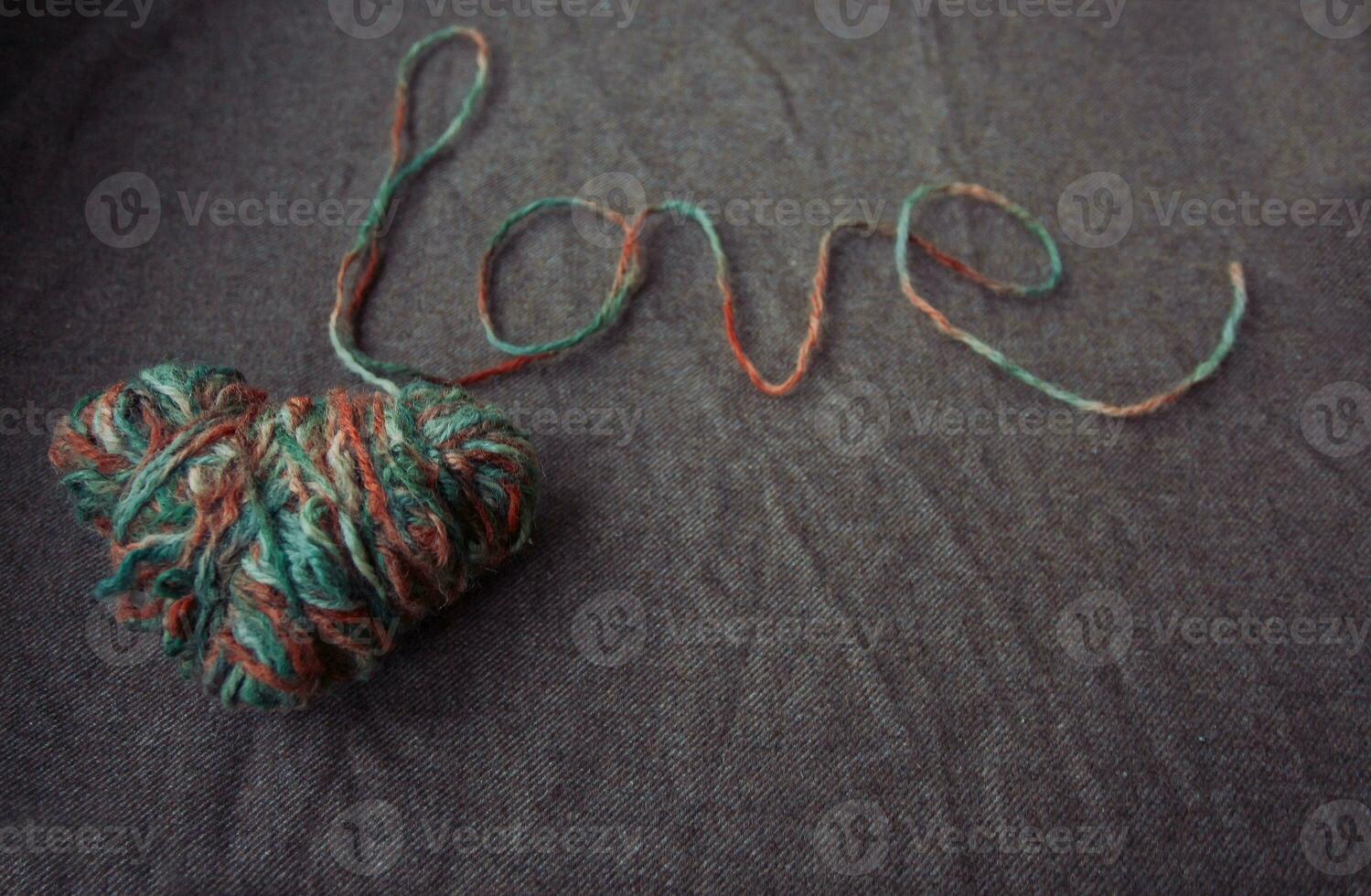 love written of wool yarn on a brown background photo