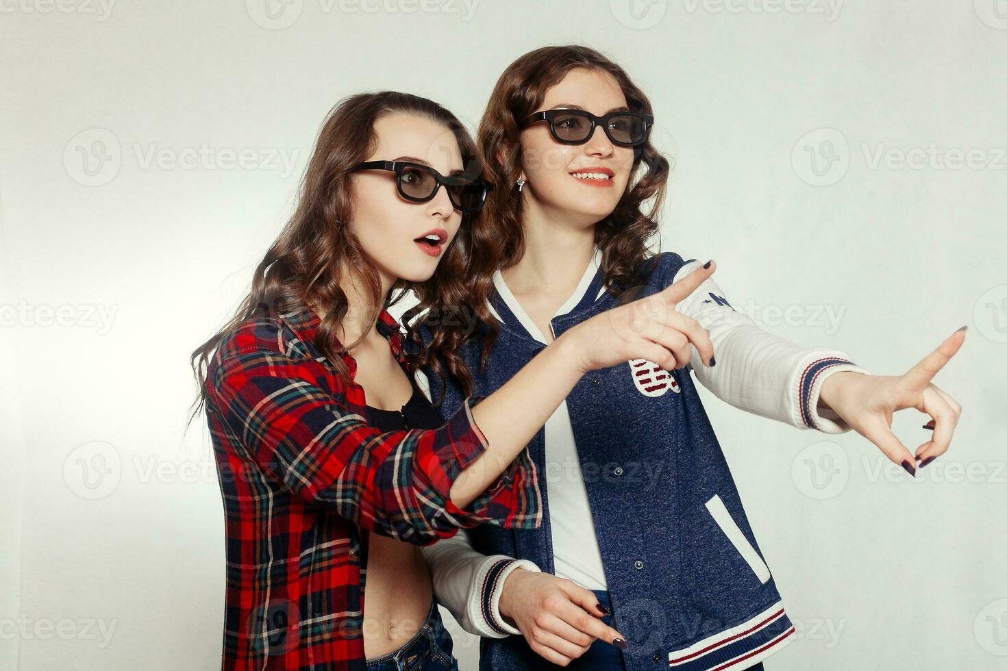 Two attractive smiling girl in a 3d-glasses photo
