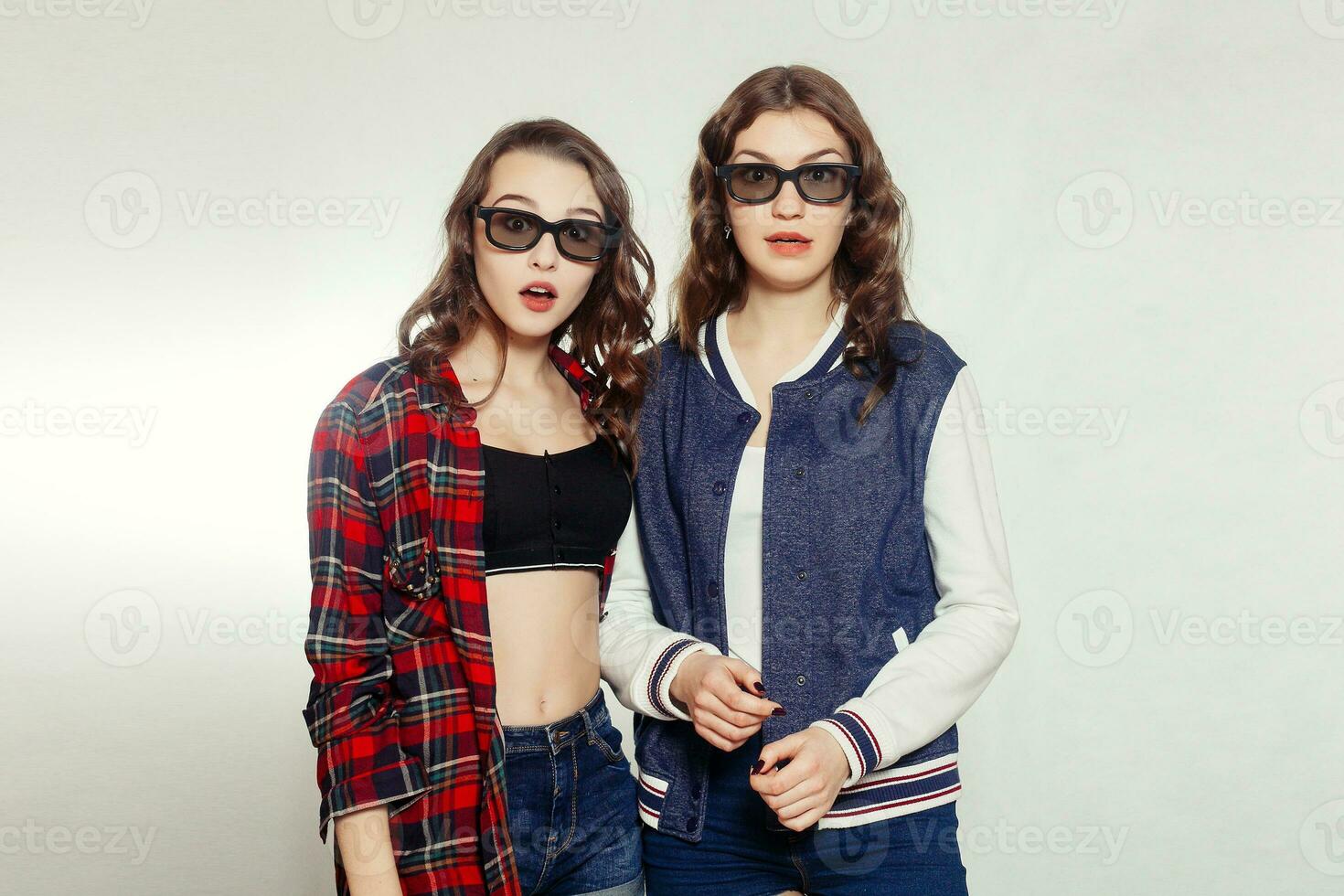 Two attractive smiling girl in a 3d-glasses photo