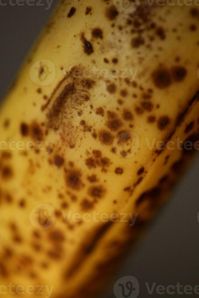 Banana with dark spots with shadow isolated close up macro botanical food porn backgrounds selective focus big size high quality instant printings photo