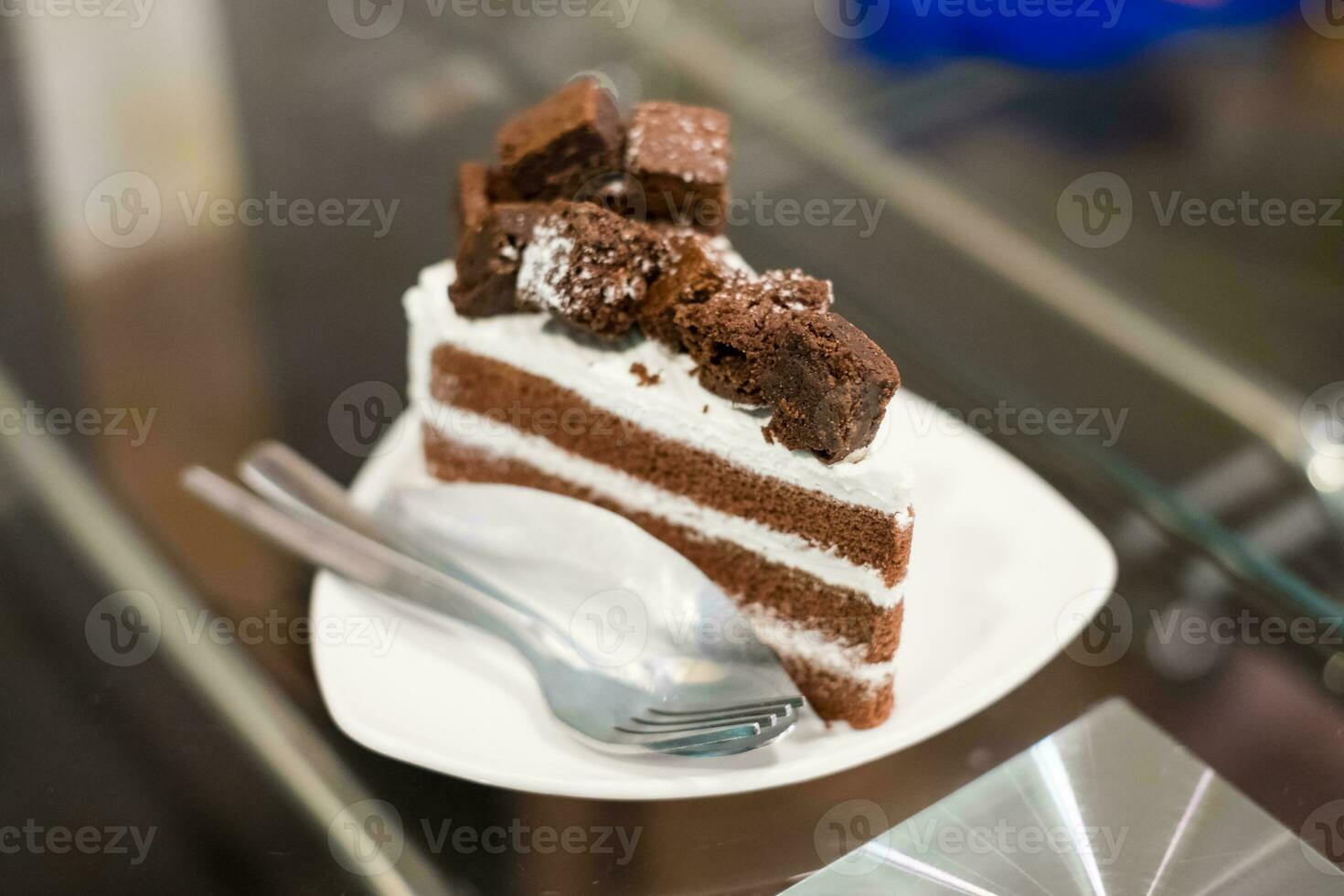 Chocolate cake and white cream on table photo