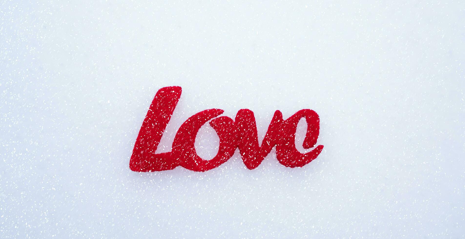 Love message the word LOVE on the snow. Valentine's Day. Banner. Close-up. Top view. Selective focus. photo