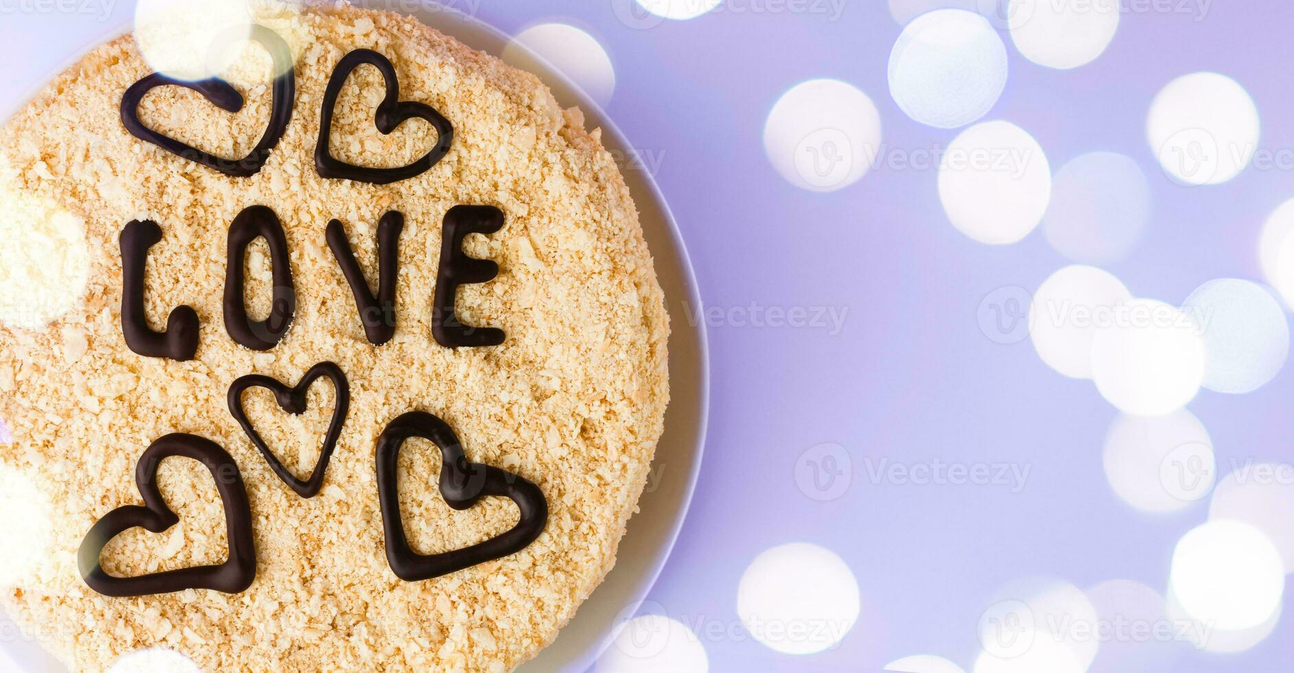 The cake with chocolate hearts and chocolate inscription Love on a background using the color of 2022 Very peri. Baking for Valentine's Day, Mother's Day and Birthday. Copy space. photo