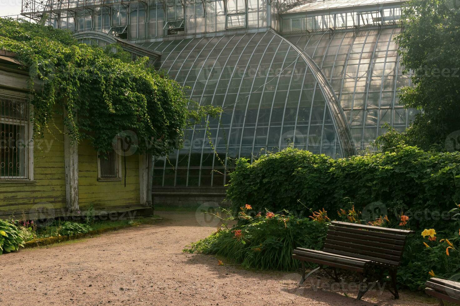 esquina de un antiguo botánico jardín con un enorme Clásico invernadero en el antecedentes foto