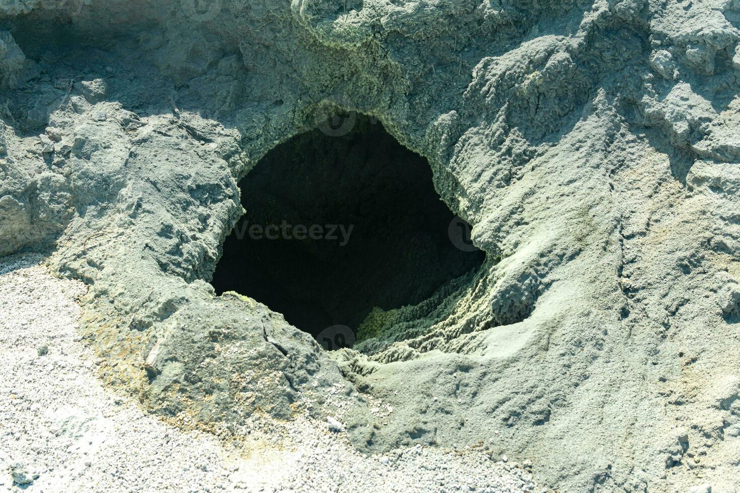 vent of a volcanic fumarole in the ground, covered with crystalline sulfur photo