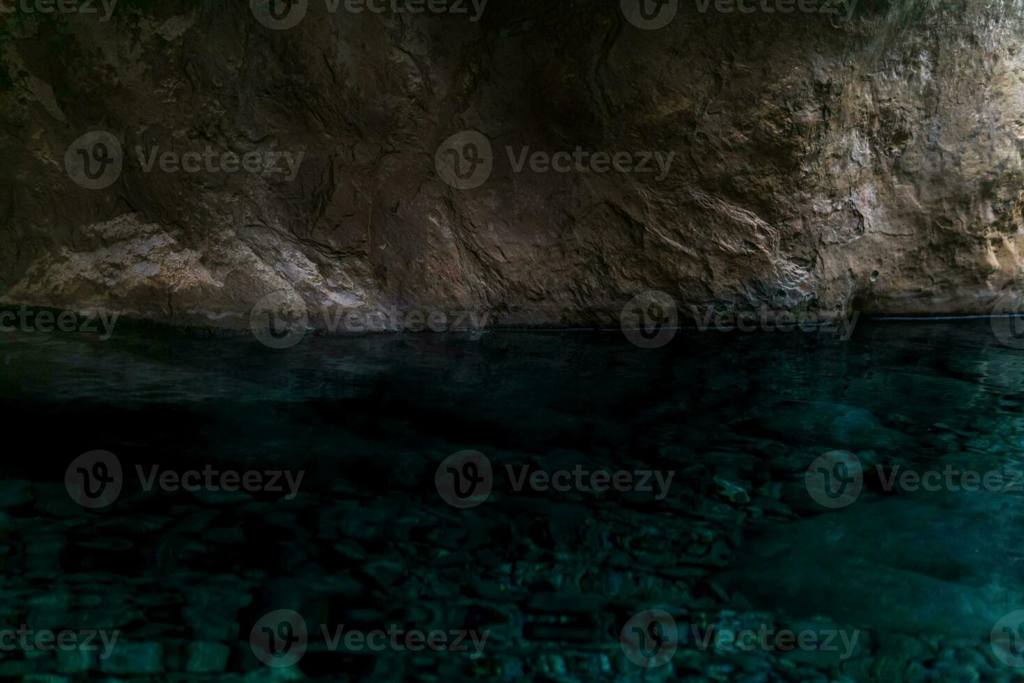 clean underground cave river in steep stone banks in the dark photo