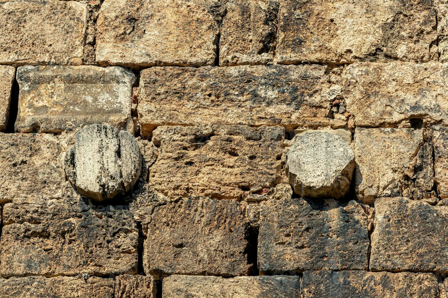 stonework of an ancient wall, antique columns are used among the bricks photo