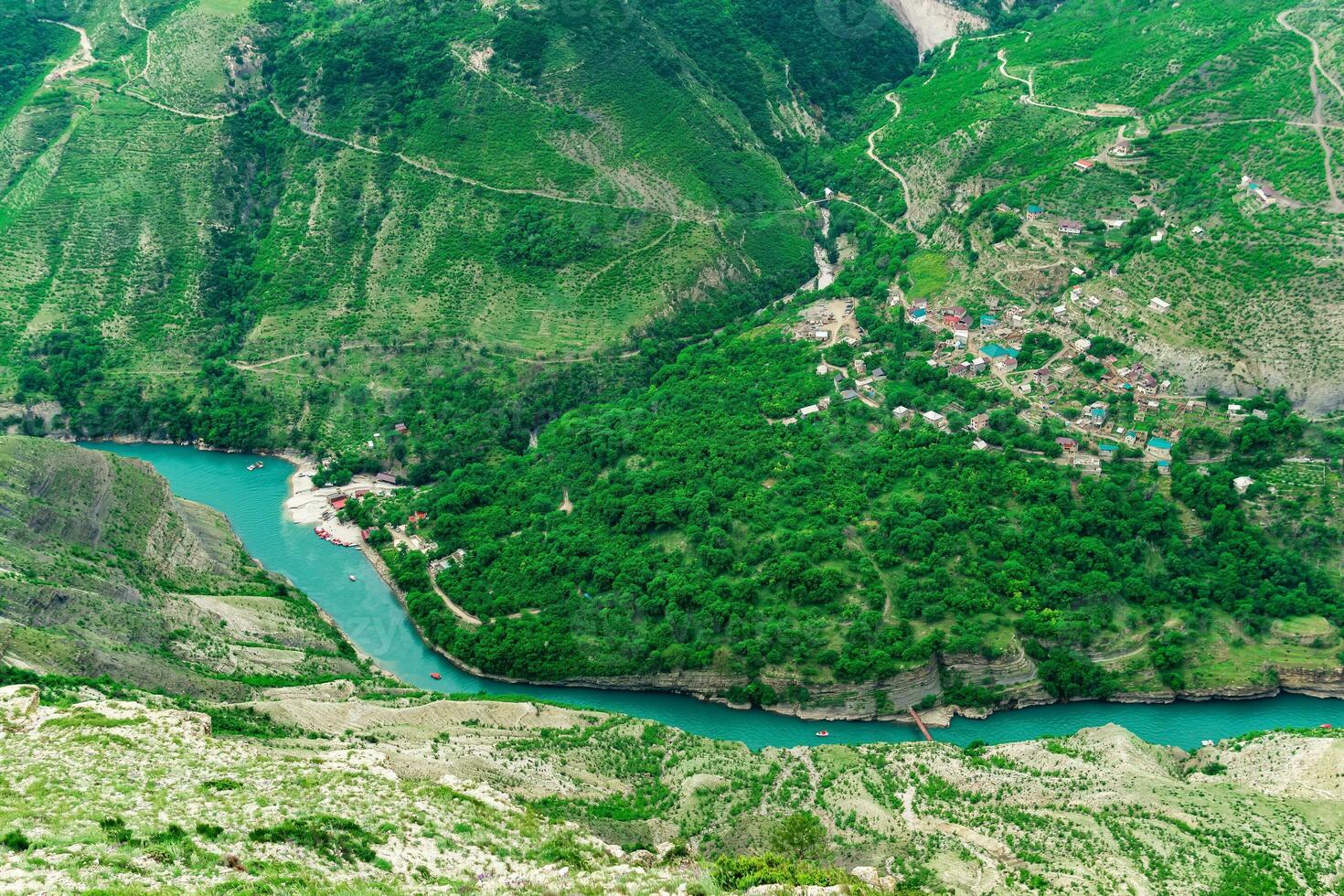 aerial view of the village of Old Zubutli in the valley of the Sulak River in Dagestan, small mountain settlement in a deep canyon with a jetty for motorboats photo