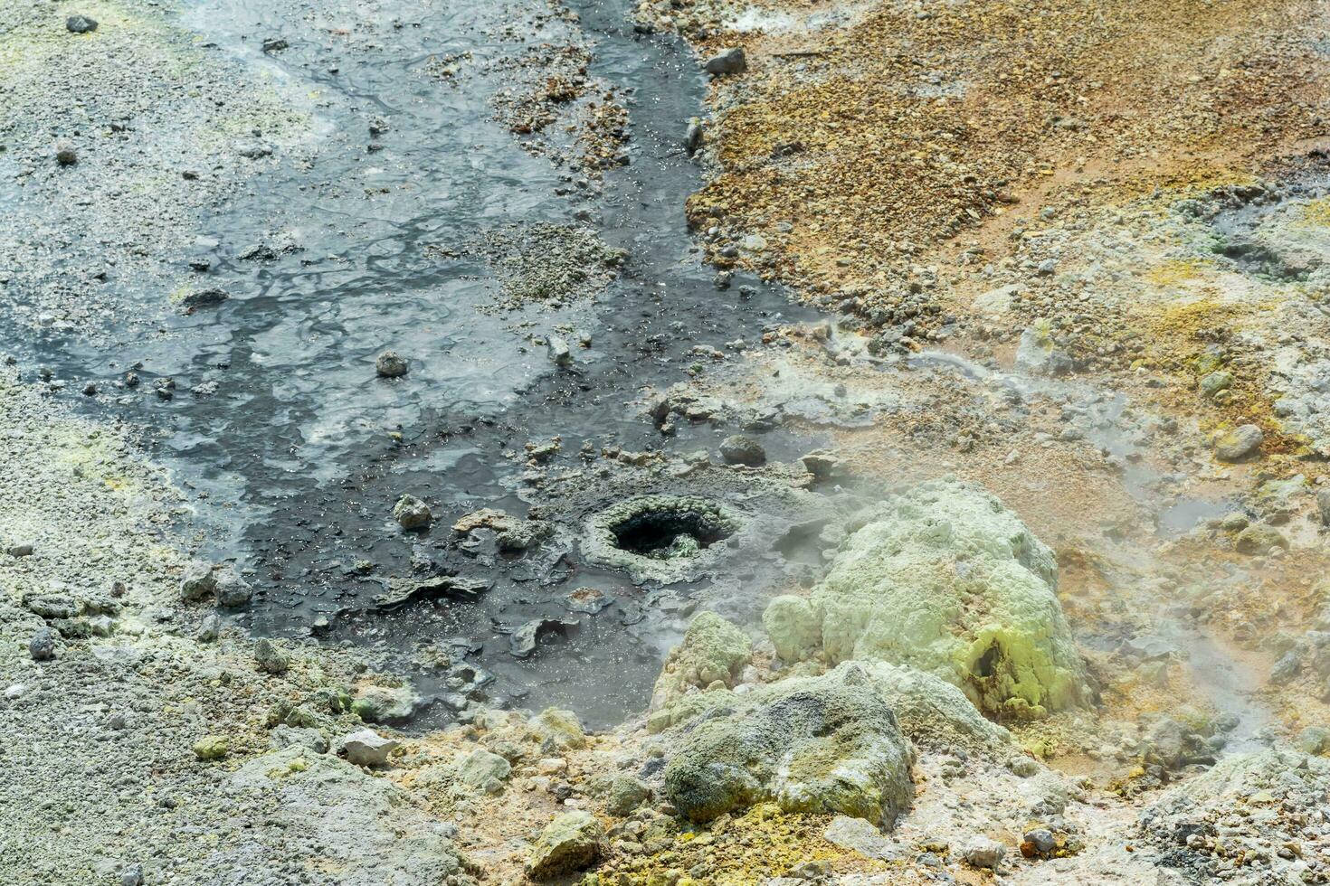 boiling fumaroles and sulfur deposits at the hydrothermal outlet on the shore of the hot lake in the caldera of the Golovnin volcano on the island of Kunashir photo