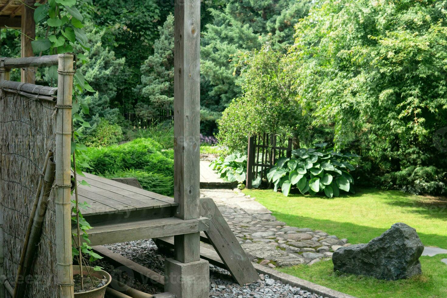 paisaje de un tradicional japonés jardín con plantas, rutas y un fragmento de un pabellón foto