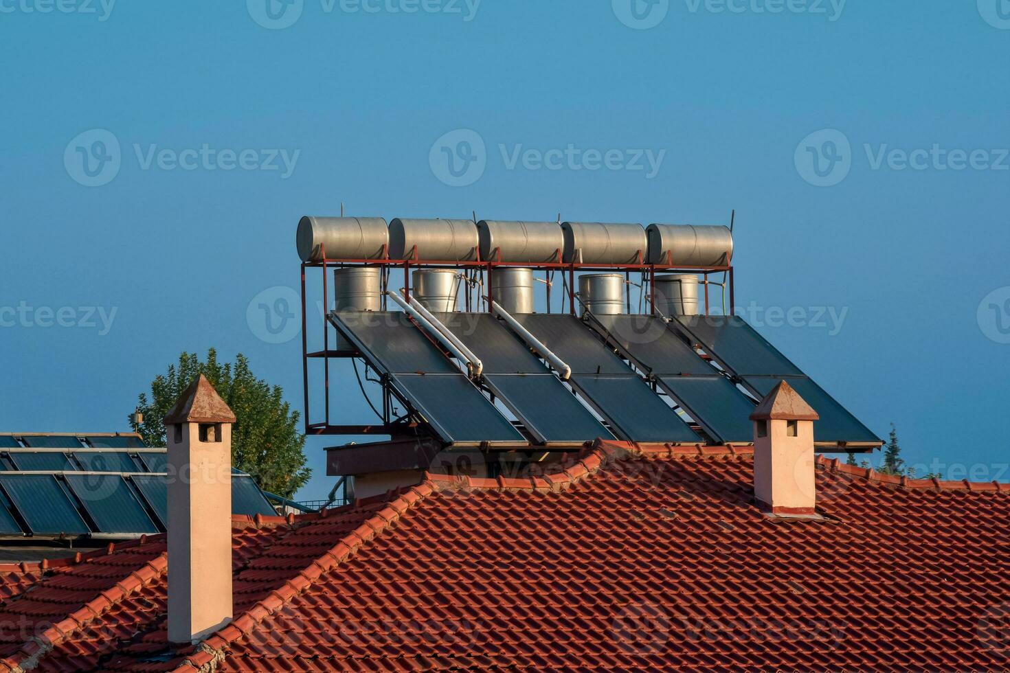 solar thermal collectors installed on the tiled roof of the house photo