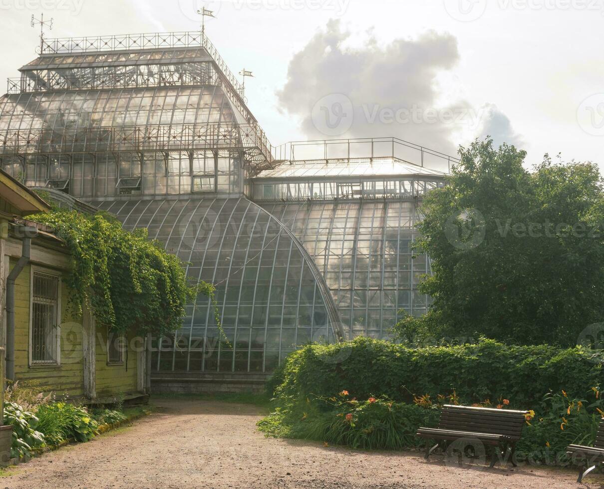 esquina de un antiguo botánico jardín con un enorme Clásico invernadero en el antecedentes foto