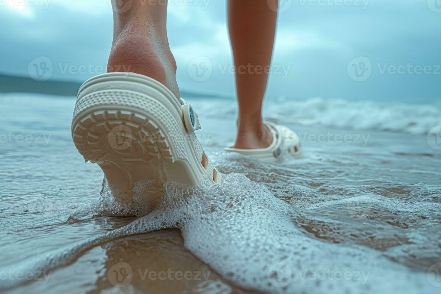 AI generated crocs shod feet of an person on the beach walking along the surf photo