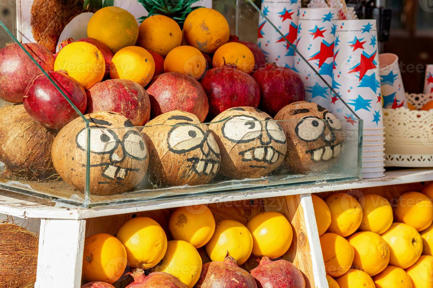 funny faces painted on coconuts on the counter of a fruit stand photo