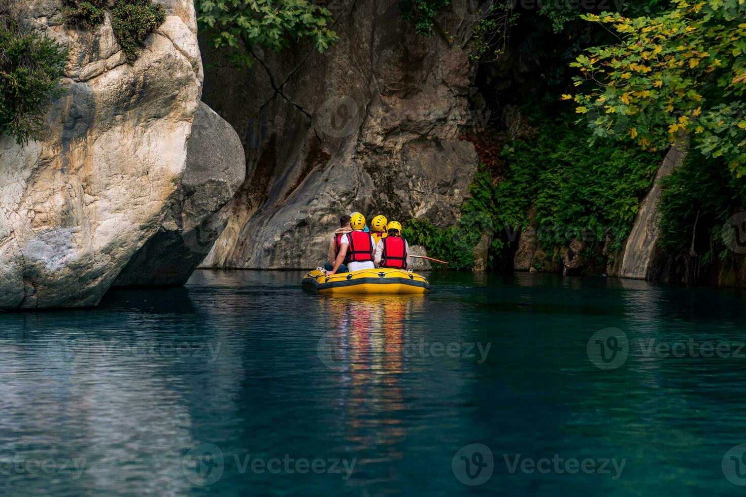 tourists on an inflatable boat rafting down the blue water canyon in Goynuk, Turkey photo