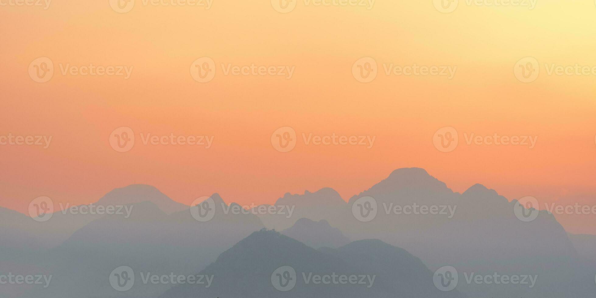 bright sunset or sunrise sky with misty mountains photo