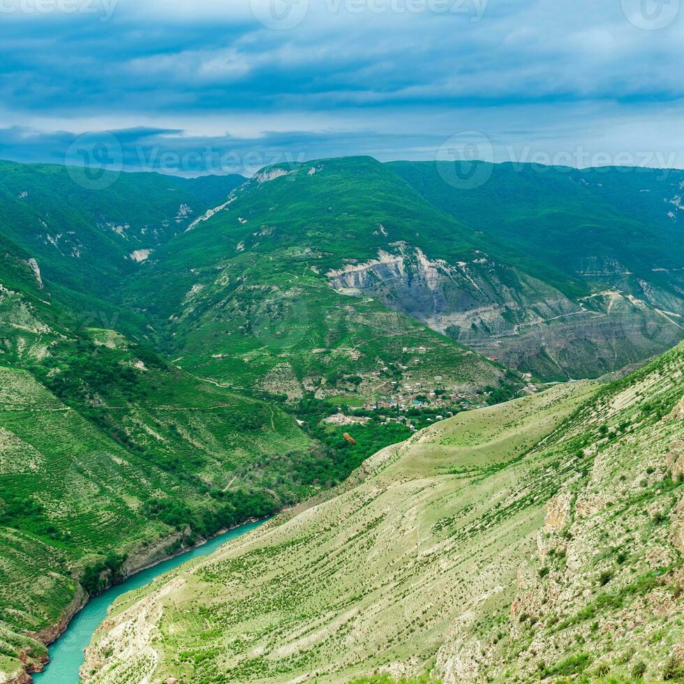 Mountain landscape in the Caucasus in Dagestan, view of the canyon of the Sulak River with the village of Old Zubutli in the distance on the slope, visible soaring vulture photo