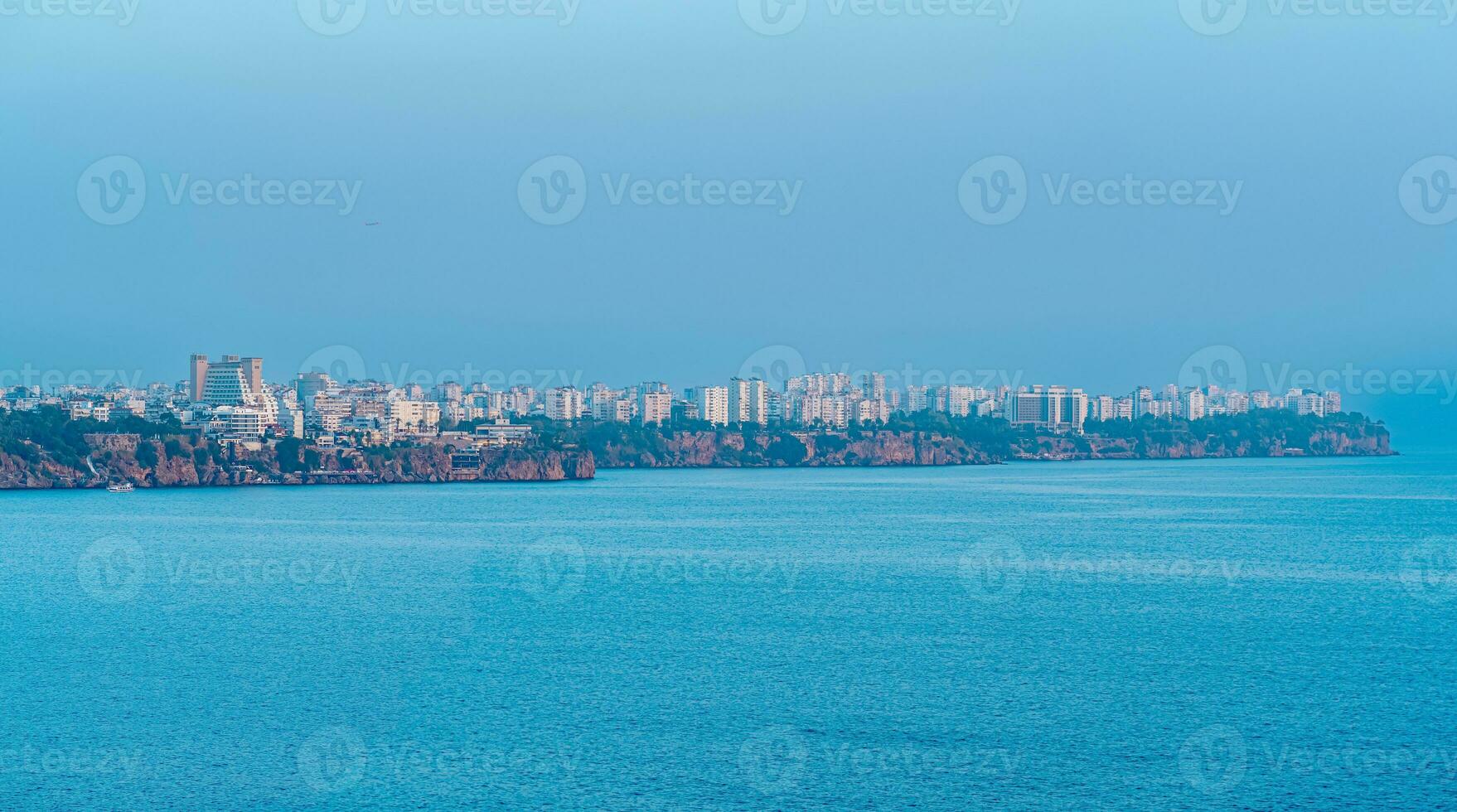 view from the sea on the coast of Antalya in a blue haze photo