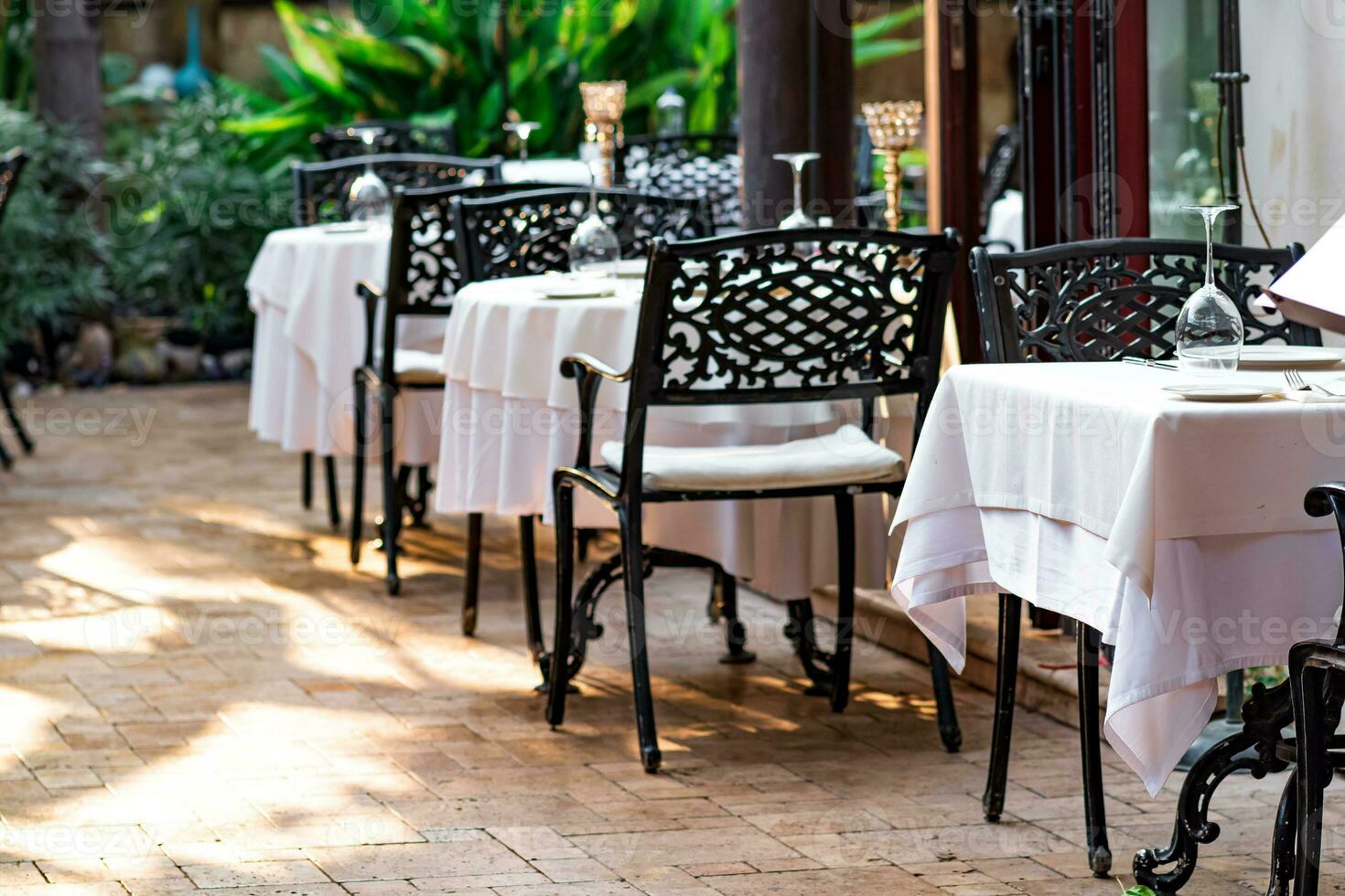 small street restaurant awaits visitors, outdoor tables set photo