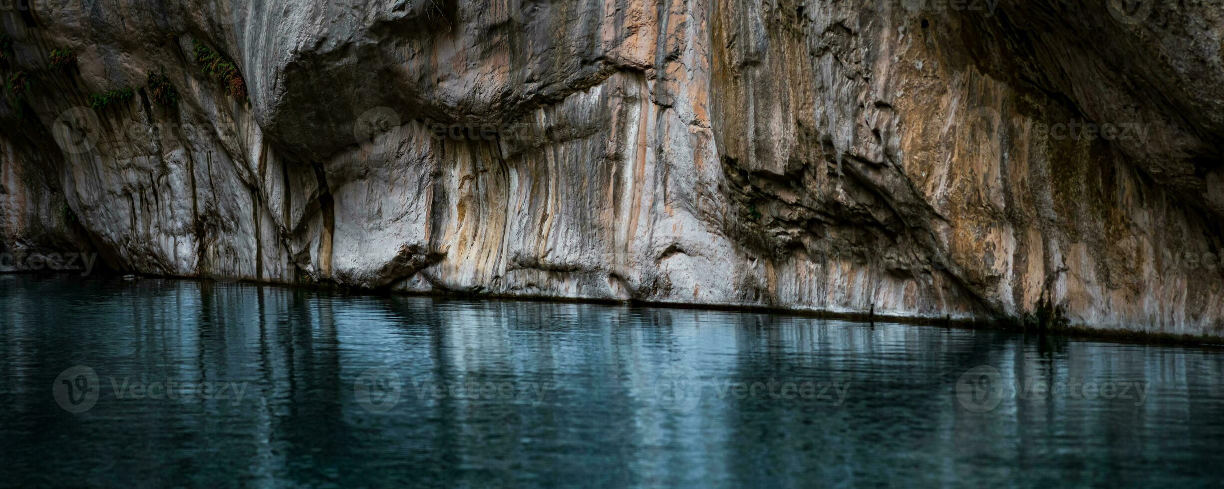 clear blue water in a deep canyon with sheer rock walls photo