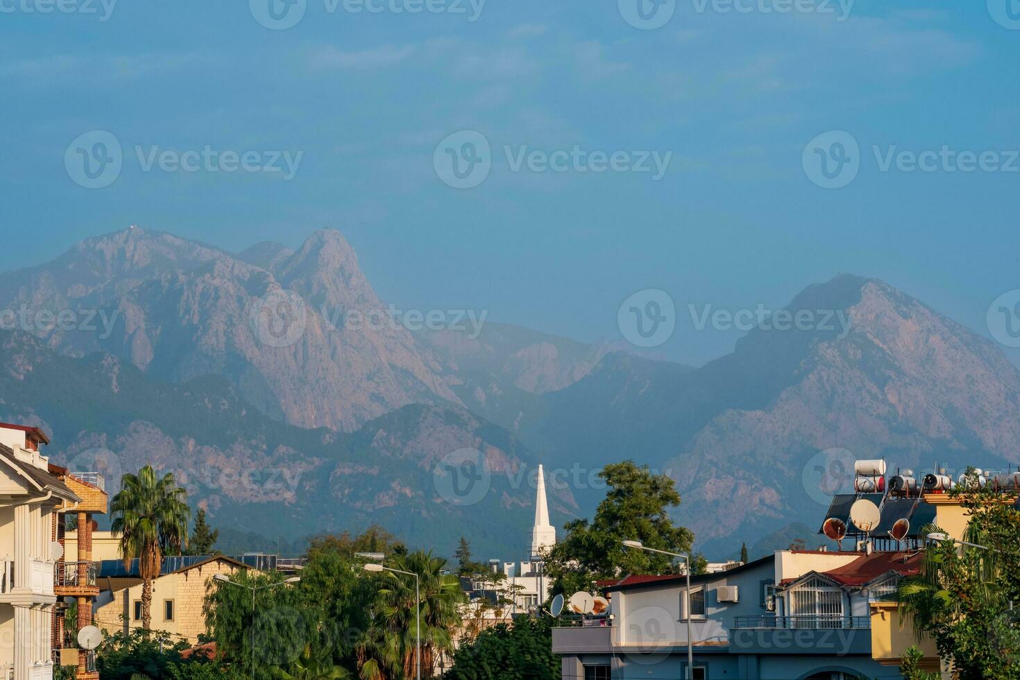 landscape with distant blue mountains behind city rooftops, Kemer, Antalya, Turkey photo