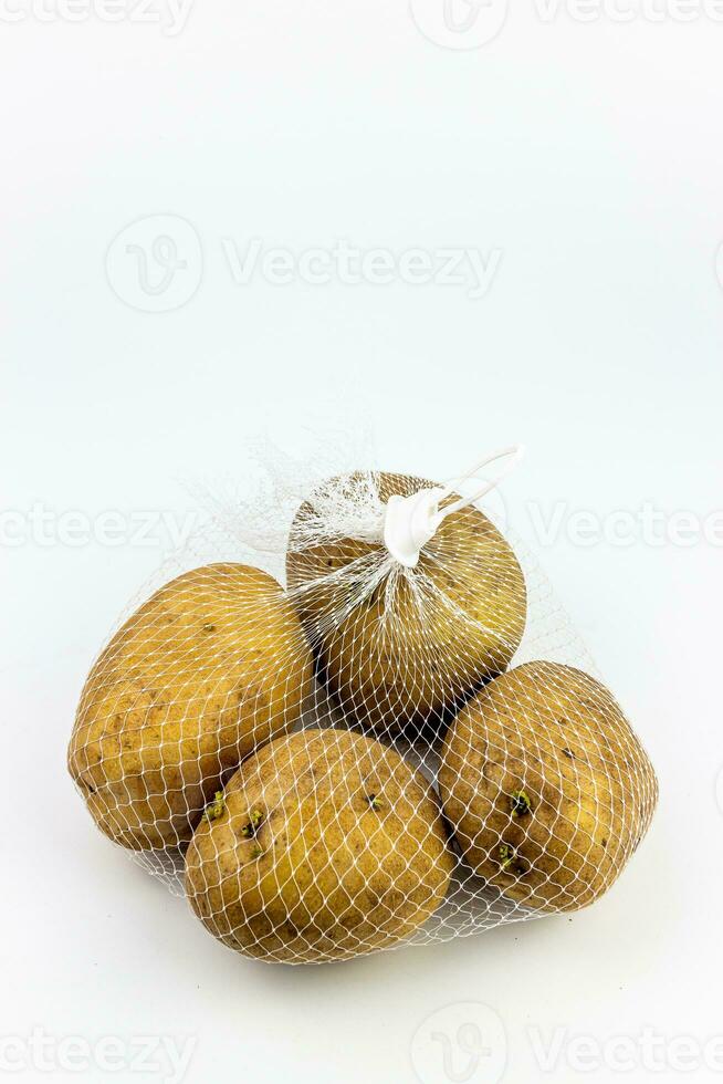 Potatoes in a mesh bag on a white background. Isolated photo