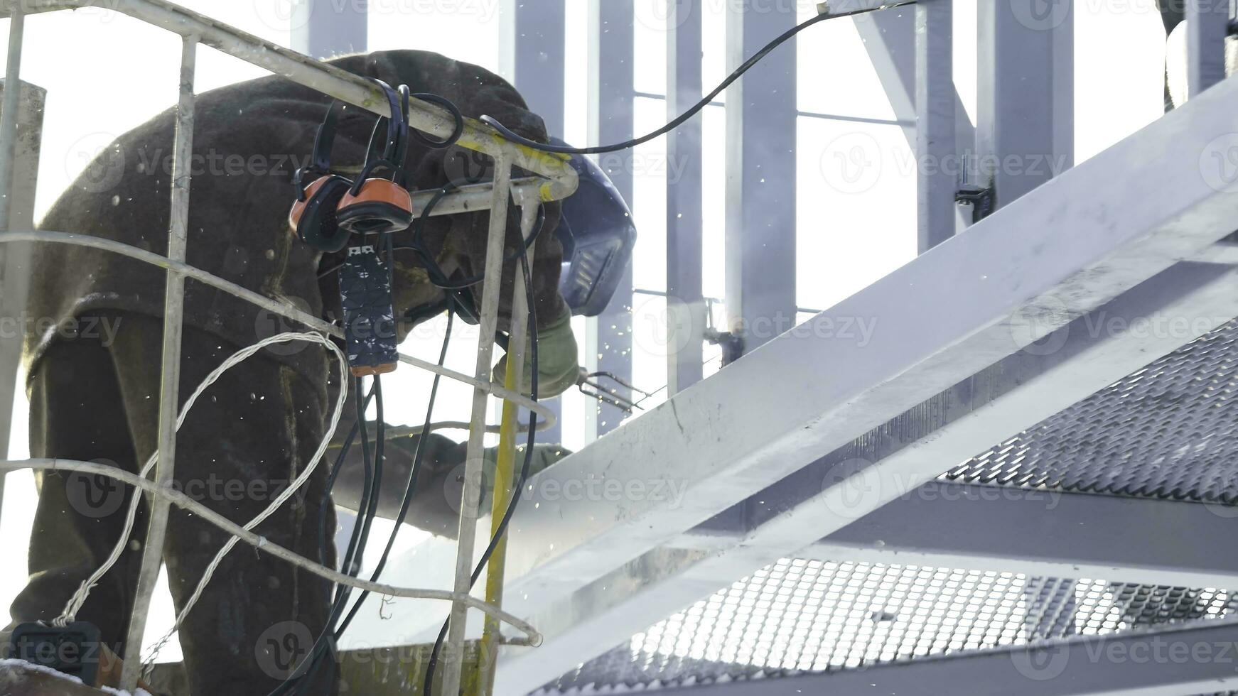 Construction workers working on scaffolding, Man Working on the Working at height with blue sky at construction site. Worker using electric wheel grinding on steel structure in factory. Work on high photo