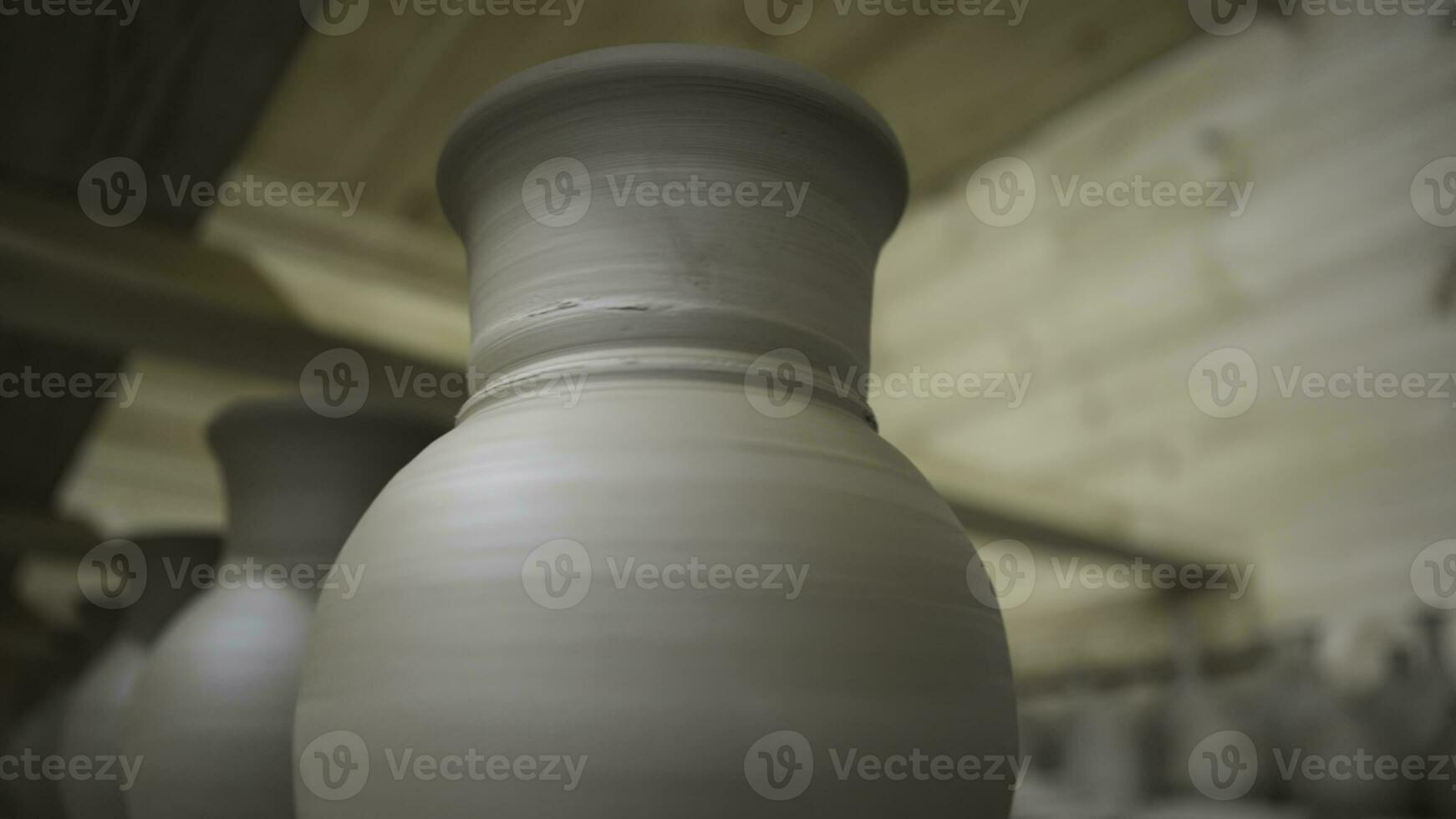 Close up of set of clay ceramic jugs and lids while drying. Stock footage. Row of hand made clay pots standing in hot wooden room, ceramics and manufacture concept. photo