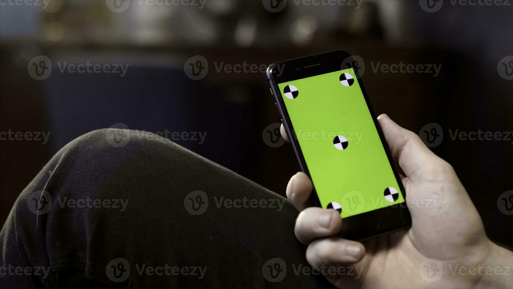 Man using mobile smartphone at home. Stock footage. Close up of a phone with a green screen in the hands of a man photo