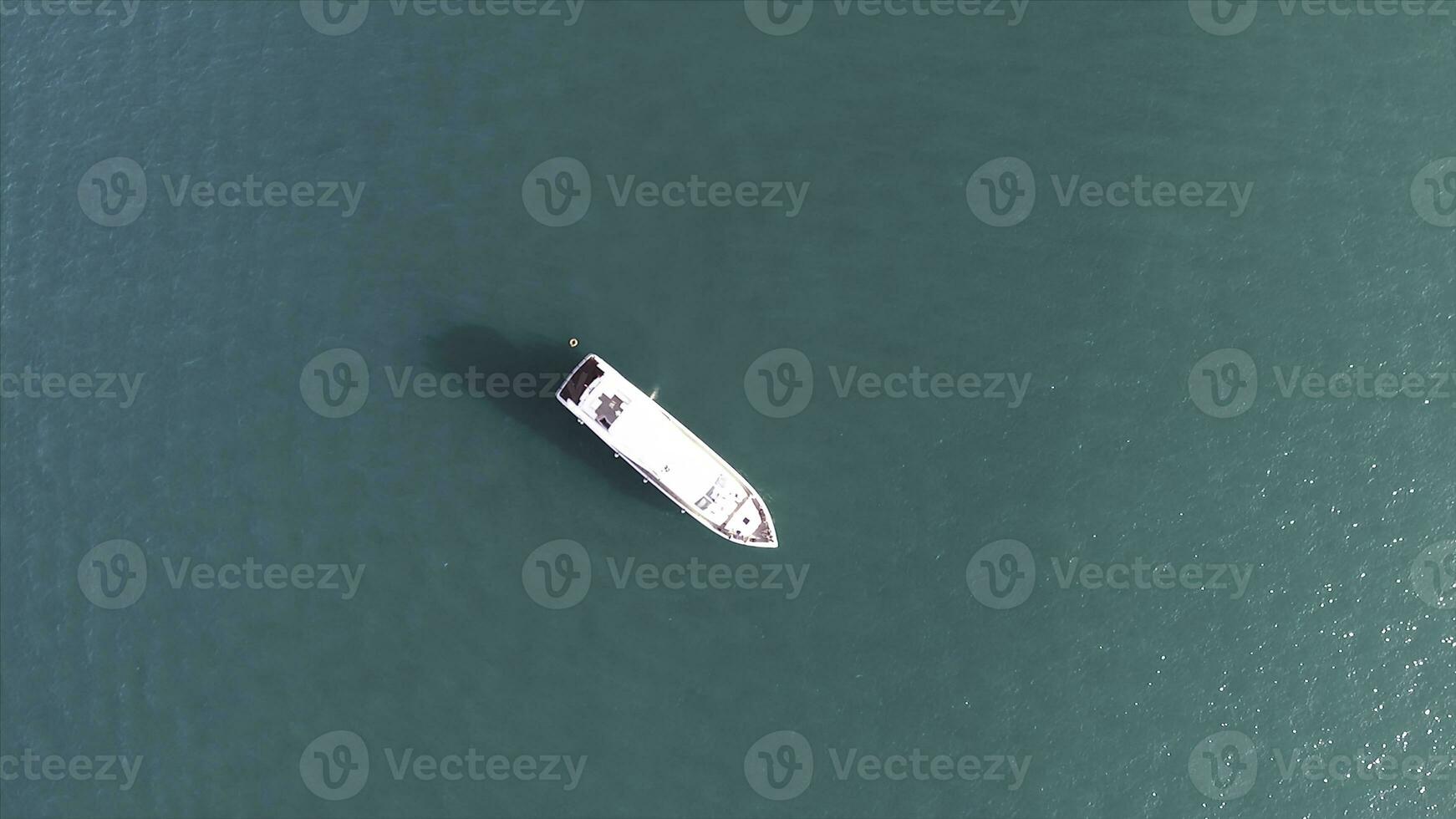 Aerial drone bird eye top view of white beautiful yacht in turquoise clear water of Greece. Stock. Turquoise water background with white ship, summer seascape. photo