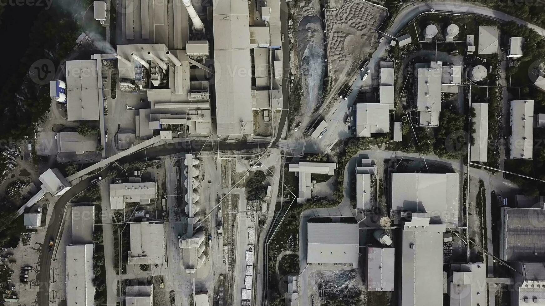 Aerial top view of buildings and materials warehouse in the industrial city zone from above. Stock footage. Many roofs of buildings, plants and warehouses at urban industrial zone. photo