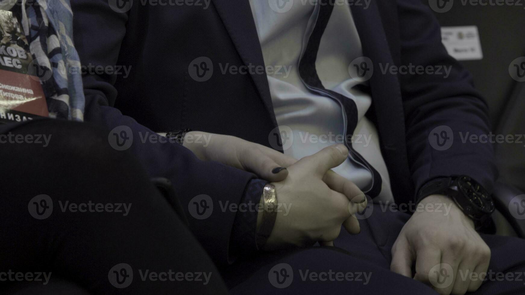 Two people holding hands. Close up view of man holding hands of a woman sitting on sofa indoors. Close-up hands together of young man and woman indoors photo