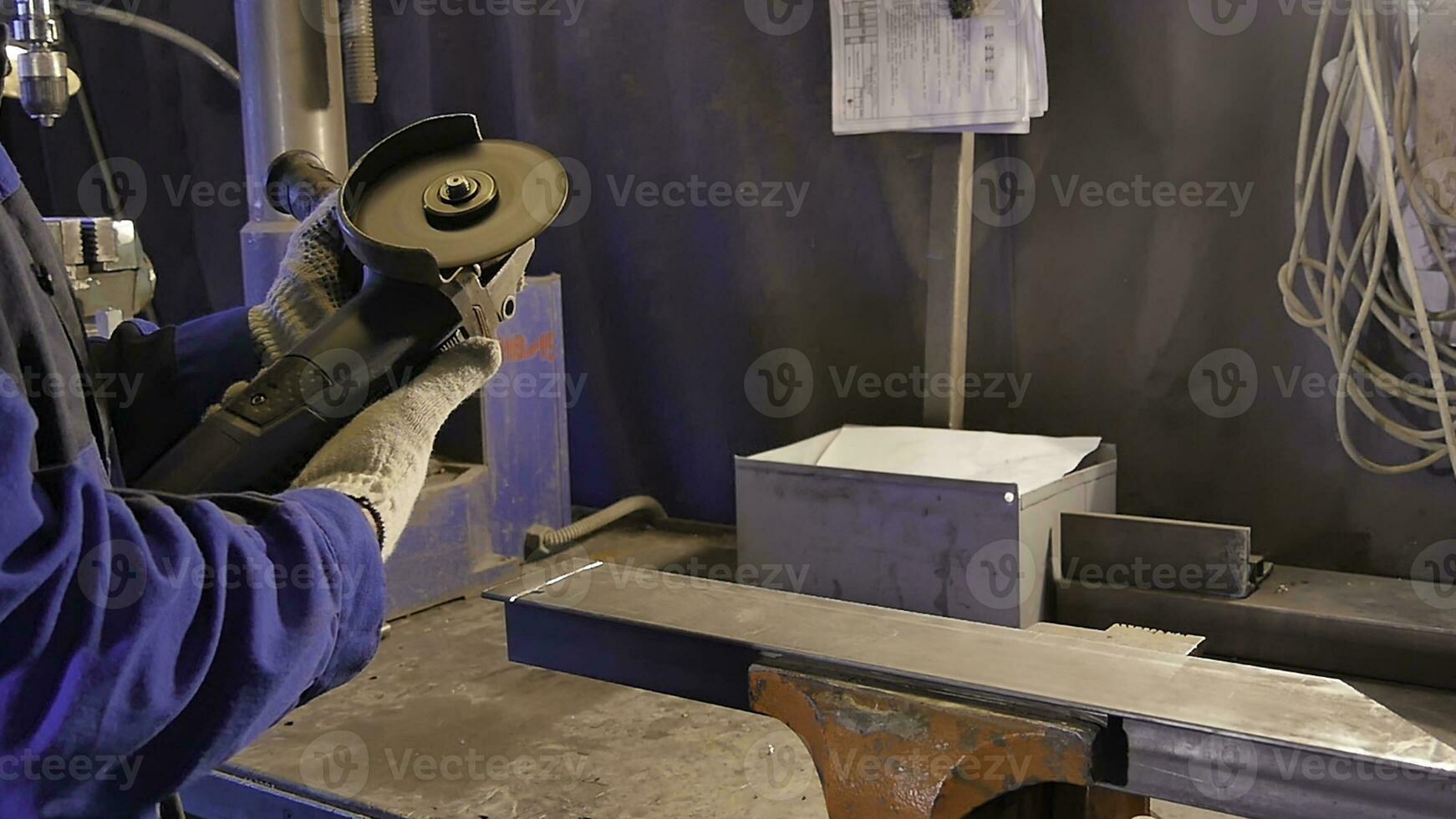 Craftsman sawing metal with disk grinder in workshop. Metal sawing close up. Worker in production sawing metal. Industry in slow motion photo
