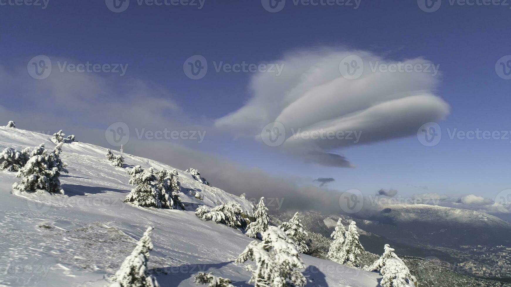 fantástico invierno paisaje de alto montaña y Nevado bosque en nublado, azul cielo antecedentes. disparo. soleado día en blanco, invierno rocas y arboles cubierto con nieve en contra brillante cielo. foto