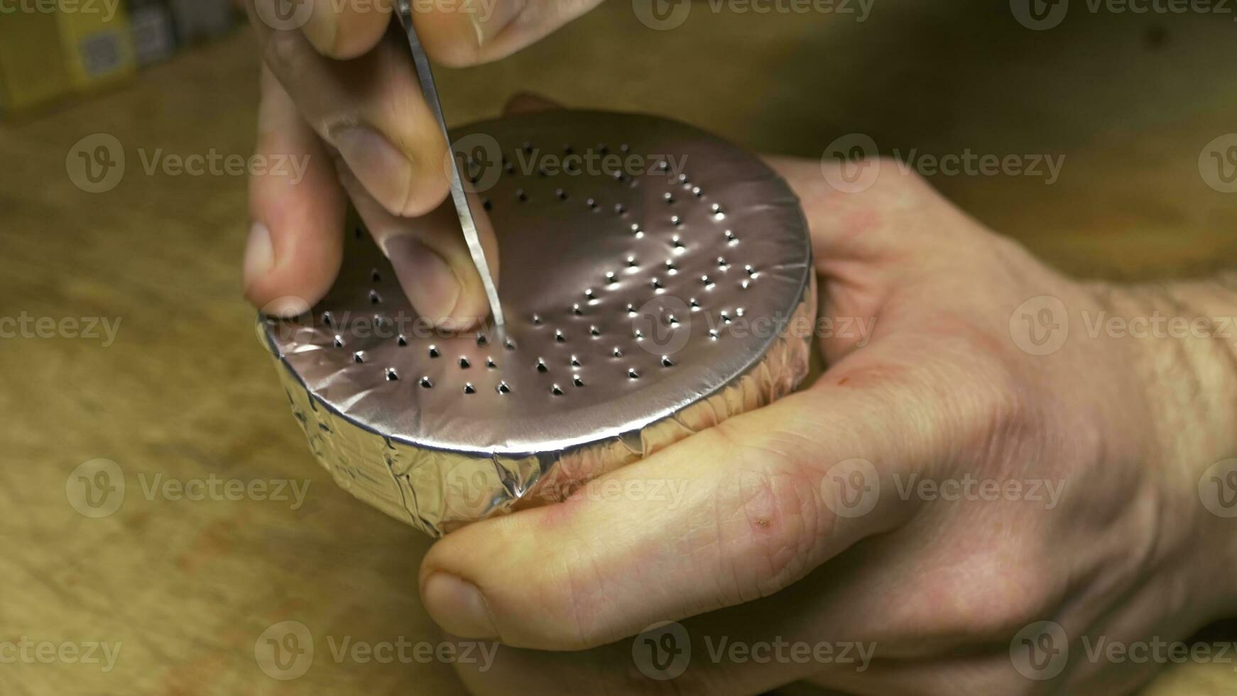 A man prepares a hookah with foil. stretching of the foil on Shisha bowl. Hookah. tobacco preparation. Preparing the shisha, aka nargile or hookah at a restaurant by placing the charcoals on top photo